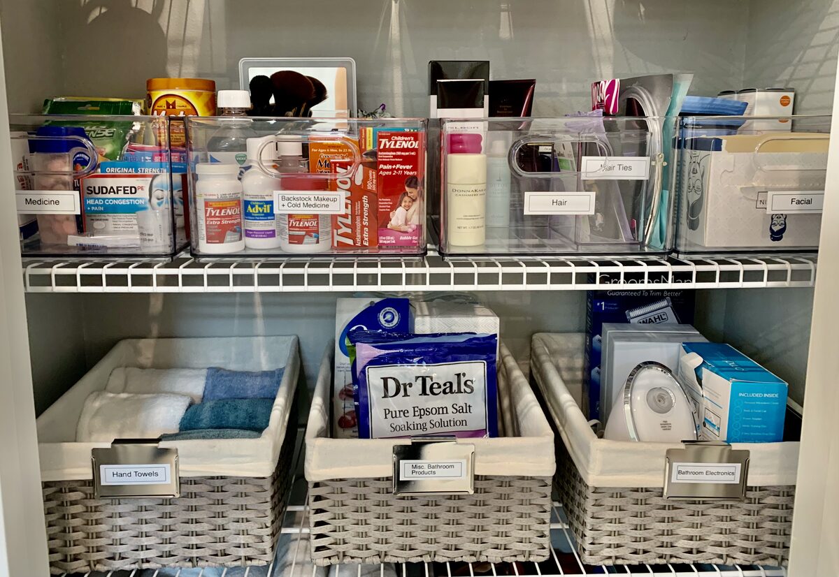 Bathroom open shelves restocked with matching containers and decluttered surfaces — Simply Spacial Sarasota
