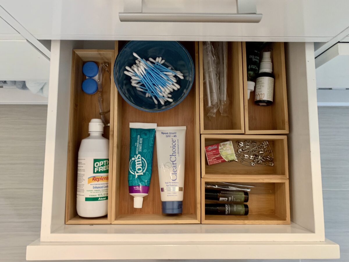 Under-sink bathroom storage organized with clear bins and product categories — Simply Spacial in-home organizing, Sarasota FL