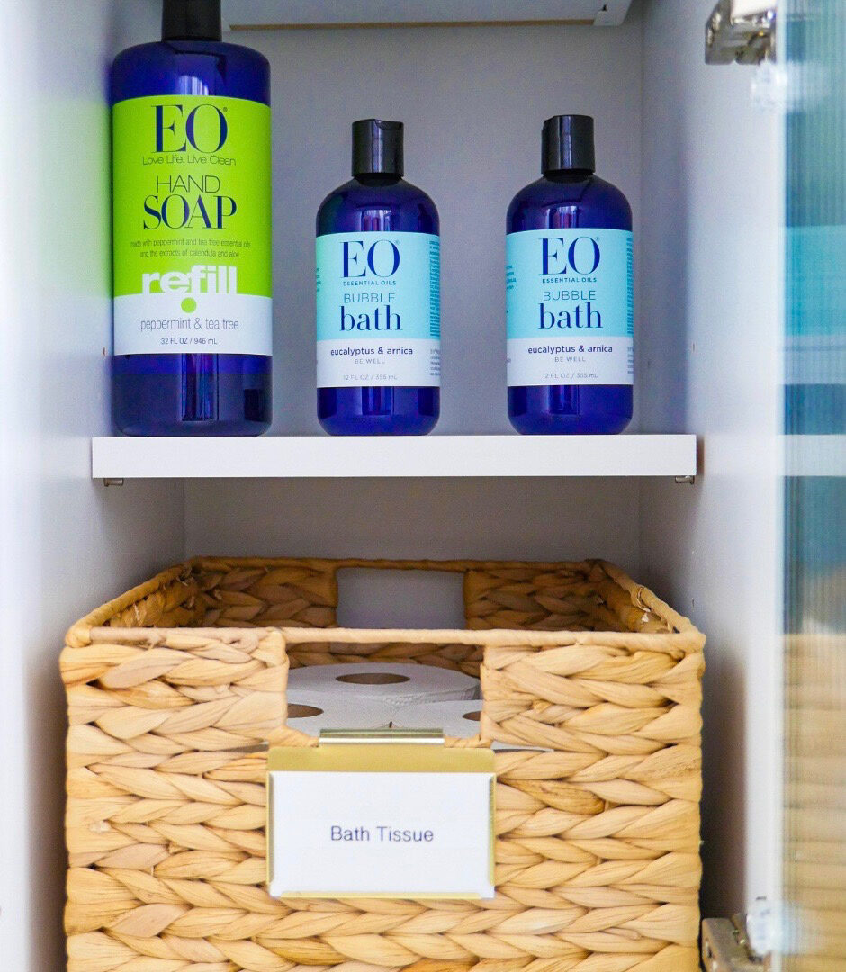 Bathroom cabinet with clear bins, grouped product categories, and open visibility — Simply Spacial in-home organizing, Venice FL