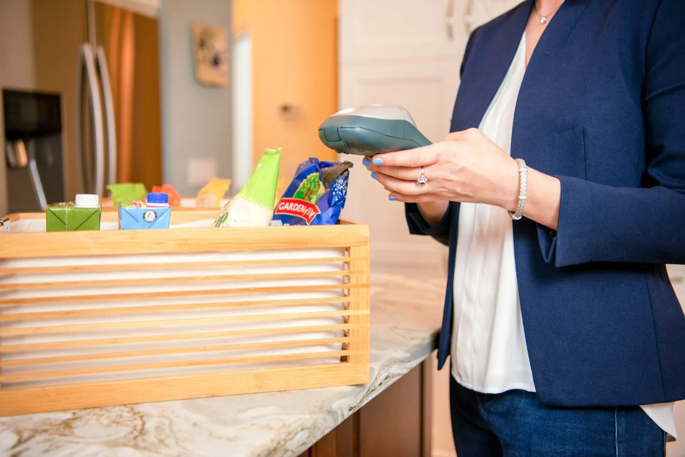 Kim labeling a bin of pantry snacks